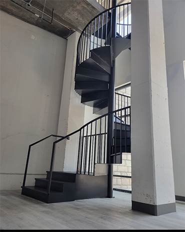 Modern spiral metal staircase with polished railings and smooth curves